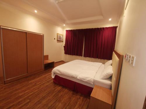 麦地那فندق اجنحة طيبة的一间卧室配有床和红色窗帘