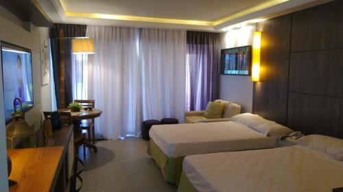 布希奥斯Buzios Beach Resort Apartamento Luxo Home Premium的酒店客房设有两张床和一张桌子。
