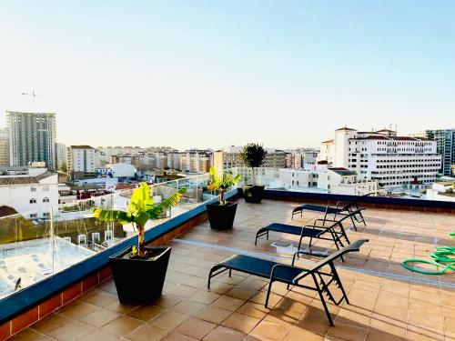 直布罗陀Gibraltar Central Suites的大楼顶层阳台,配有桌椅
