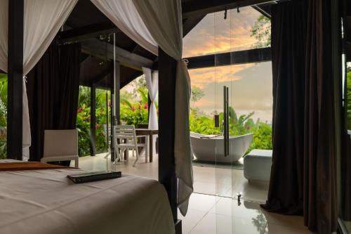 乌维塔Oxygen Jungle Villas & Spa的一间卧室设有浴缸和一张美景床。