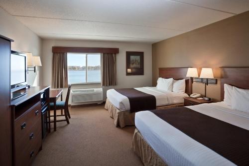 Fort PierreAmericInn by Wyndham Fort Pierre Conference Center的酒店客房设有两张床和电视。