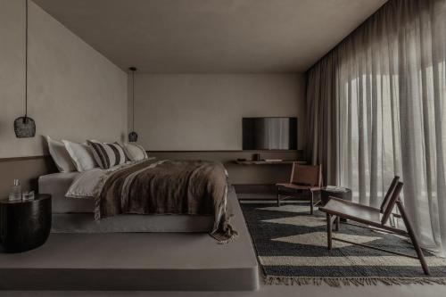 毕达哥利翁Casa Cook Samos - Adults only的一间卧室配有一张床、一把椅子和一张书桌
