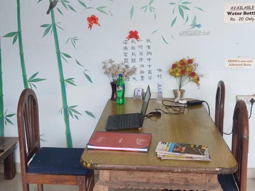 阿格拉Superinn home stay& guest house的一张木桌,上面有一台笔记本电脑
