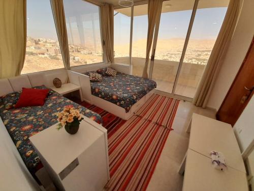 瓦迪穆萨Jordan Guest House的一间配有沙发、一张床和窗户的客房