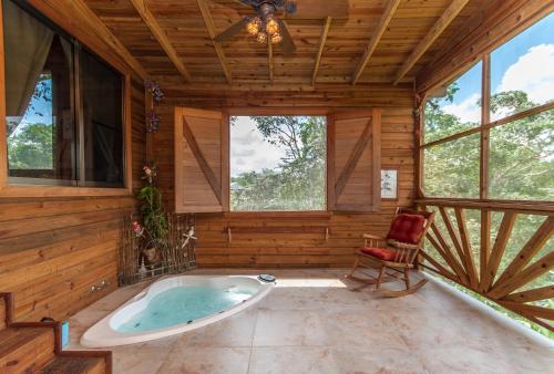 Teakettle VillageDream Valley Belize的带窗户的客房内的按摩浴缸