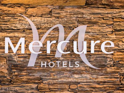 比居格利亚Mercure Hotel & Spa Bastia Biguglia的石墙上的魔法酒店标志