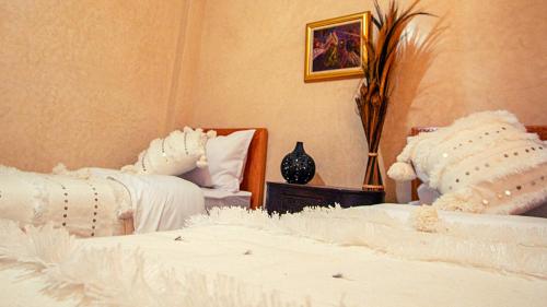 塔哈佐特THE HORIZON的配有2张床的带白色毯子和枕头的客房