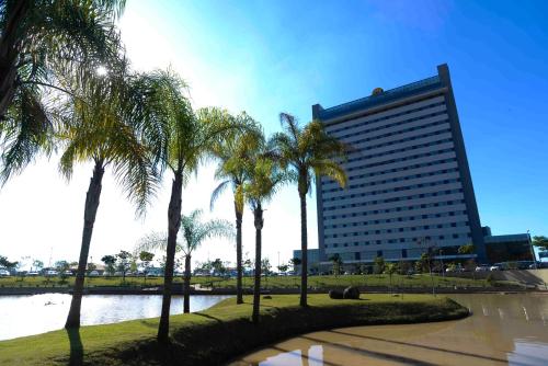 阿帕雷西达赖尼亚巴西酒店的一座棕榈树环绕的大建筑