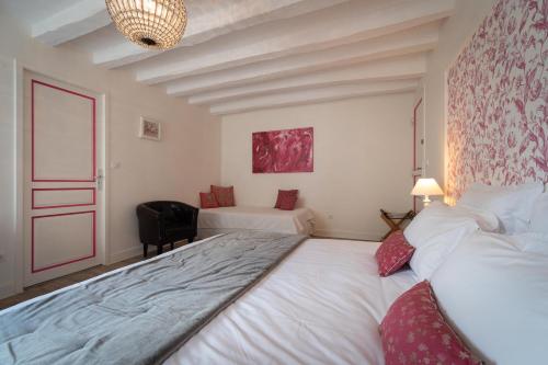 FrancueilLe Clos de La Rousselière B and B的卧室配有一张白色大床和一把椅子