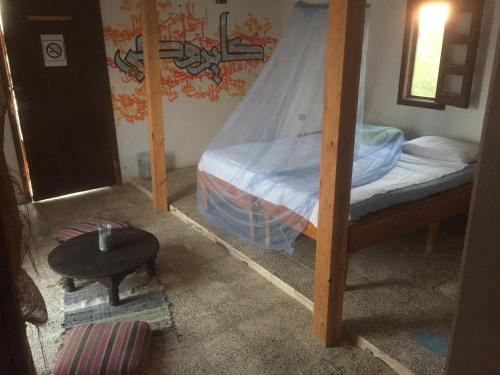 马萨阿拉姆Deep south Eco-lodge的一间卧室设有两张双层床和一张桌子