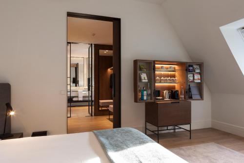 布达佩斯Kozmo Hotel Suites & Spa - Small Luxury Hotels of the World的一间卧室配有一张床和一面大镜子