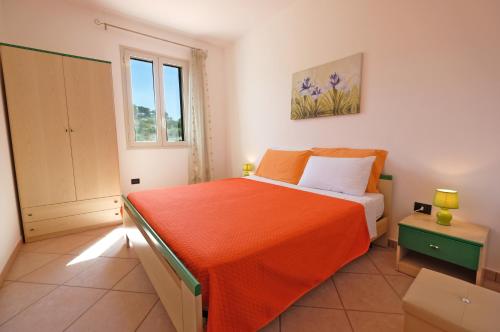 托雷瓦多Lorinne Vista Mare Torre Vado的一间卧室配有一张带橙色毯子的床