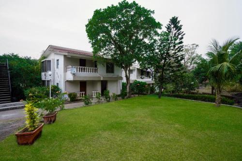 孟买EKO STAY- Tropical Villas的前面有绿色草坪的房子