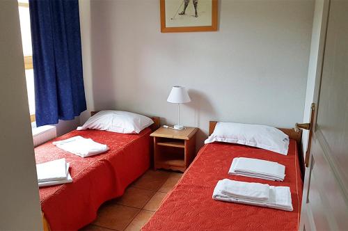 阿梅尔斯克维Goélia Le Domaine du Golf的客房设有两张床和一张带台灯的桌子。