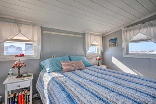 南金斯敦Seaside SK Getaway Steps to Matunuck Beach!的一间卧室配有一张蓝色棉被和两个窗户。