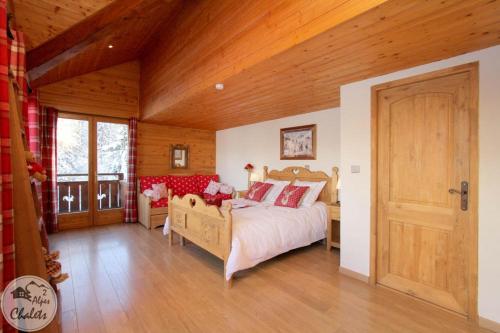 莱德萨阿尔卑斯2AlpesChalets - Chalet Marie 2 - Standing et Sauna aux pieds des pistes的一间卧室设有一张床和木制天花板