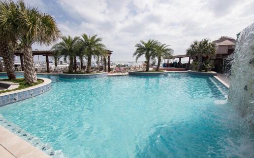 加尔维斯敦加多的海滨汽车旅馆的度假村内一座种有棕榈树的大型游泳池
