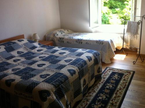Rocca D'ArazzoCasale di Charme Bellaria的客房设有两张床、一个窗户和一个地毯。