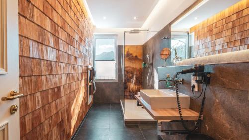 巴特莱辛哈尔Villa Sonnenhof Boutique-Hotel的一间带水槽和砖墙的浴室