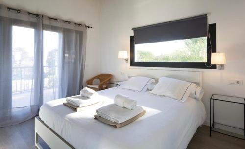 马略卡岛帕尔马Luna Bay Palma的卧室配有带毛巾的大型白色床