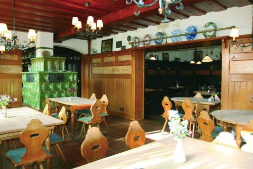 Strullendorf席勒北班贝格盖斯邵芙酒店的用餐室配有木桌和椅子