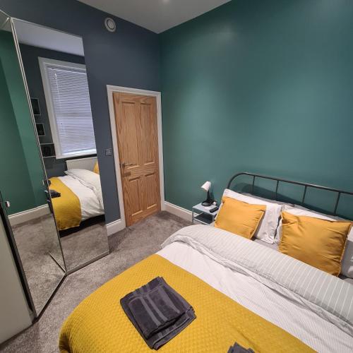 JesmondKelvin Suite的一间卧室配有两张床和镜子