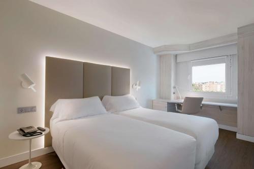 马德里巴拉哈斯机场NH酒店 的卧室设有一张白色大床和一扇窗户。