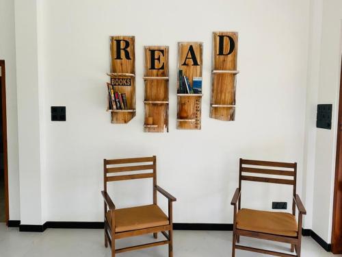 本托塔Villa Maria的两把椅子坐在墙上,墙上有书