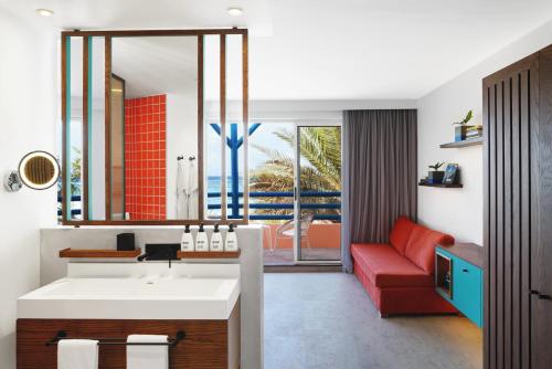 贝尔马尔Salt of Palmar, Mauritius, a Member of Design Hotels的一间带水槽和红色沙发的浴室