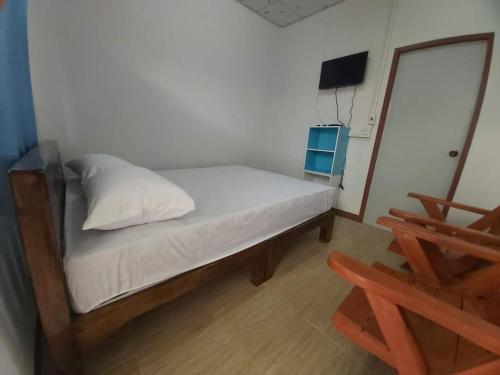 Ban Pa Tiuริมทุ่งโฮมสเตย์的一间小卧室,配有一张床和一把椅子