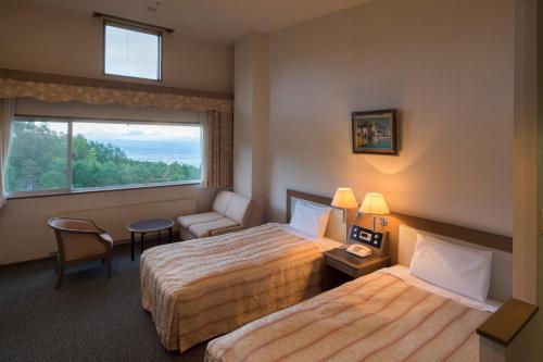 安昙野市Izumigo AMBIENT Azumino Hotel的酒店客房设有两张床和窗户。
