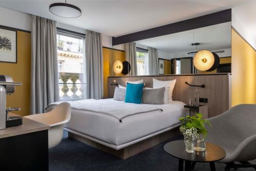 巴黎Hôtel Opéra Liège的卧室配有一张白色大床和一把椅子