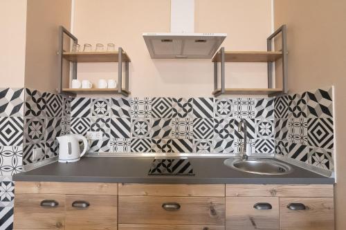 利沃夫比夫登尼酒店的厨房设有水槽和黑白瓷砖