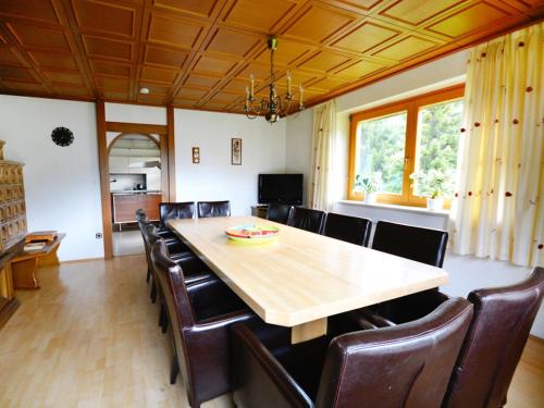 拉登泰因科夫勒拉登腾度假屋的用餐室配有大型木桌和皮椅