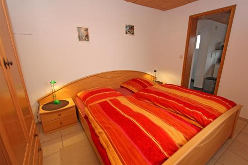 滨湖克拉科Ferienhaus Krakow am See SEE 4001的一间卧室配有一张带红色和黄色毯子的床