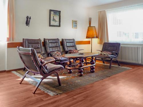 采尔马特Apartment Dianthus-1 by Interhome的客厅配有椅子、桌子和沙发