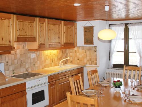 Auberson乐格朗杰吕贝尔松公寓的厨房配有木制橱柜和桌椅