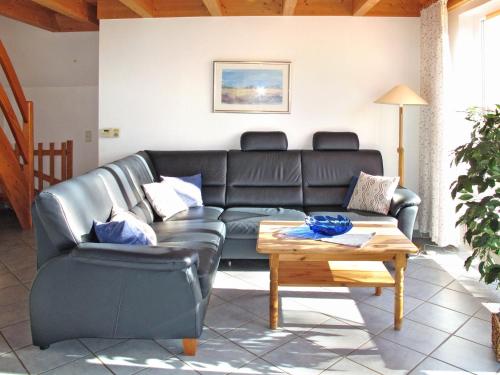 多鲁姆纽菲尔德Holiday Home Cuxland Ferienpark-1 by Interhome的客厅配有真皮沙发和茶几