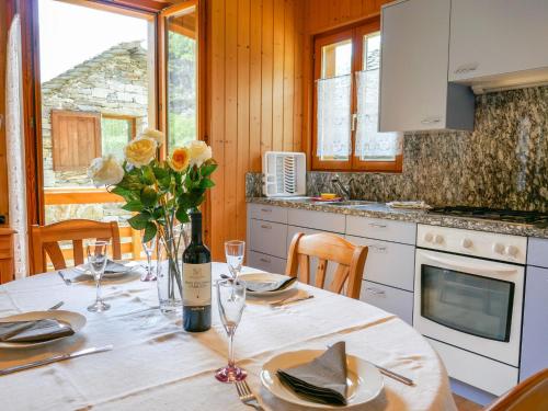 MadraChalet Rustico Casa Fortuna by Interhome的厨房配有桌子,提供一瓶葡萄酒和鲜花