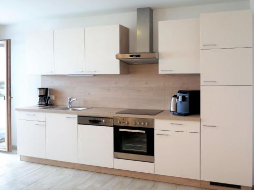 卡顿巴赫Apartment Luxner - KAB137 by Interhome的厨房配有白色橱柜和炉灶烤箱。
