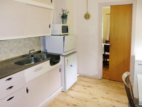 ÅseralHoliday Home Olavbu - SOW105 by Interhome的白色的厨房配有水槽和微波炉