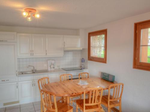 安塞热假山公寓的厨房配有木桌和木椅
