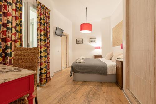 塞维利亚Hércules XCI Apartments的一间小卧室,配有一张床和镜子