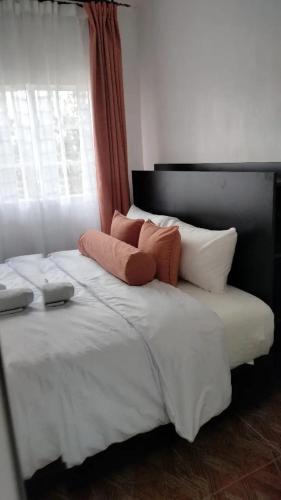 ThikaBloom private home的一张带两个枕头和窗户的大型白色床