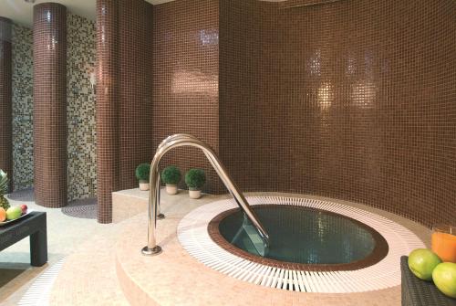 波兹南Hotel NH Poznan的一间带热水浴缸和水龙头的浴室