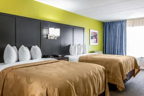 海恩斯维尔Quality Inn Hinesville - Fort Stewart Area, Kitchenette Rooms - Pool - Guest Laundry的两张床位于带黄色墙壁的酒店客房