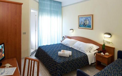 卡托利卡Hotel Queen Mary的酒店客房,配有一张带蓝白色床罩的床