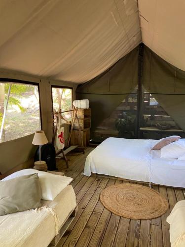 Grande Rivière Sud Est欧坦泰克生态帐篷体验酒店的一间帐篷内带两张床的卧室