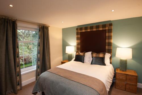 因弗内斯Parkside, The Loch Ness Cottage Collection的一间卧室设有一张大床和一个窗户。