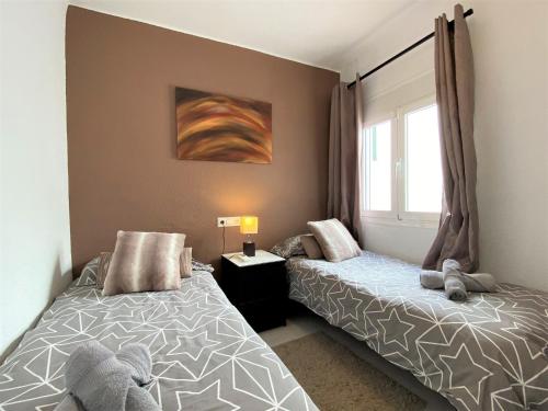 内尔哈Tuhillo 2D Seaview Apartments Casasol的一间卧室设有两张床和窗户。